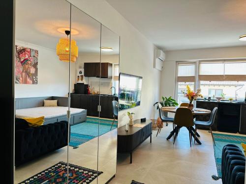 a living room with a bed and a dining room at Caro Studio in Tunari