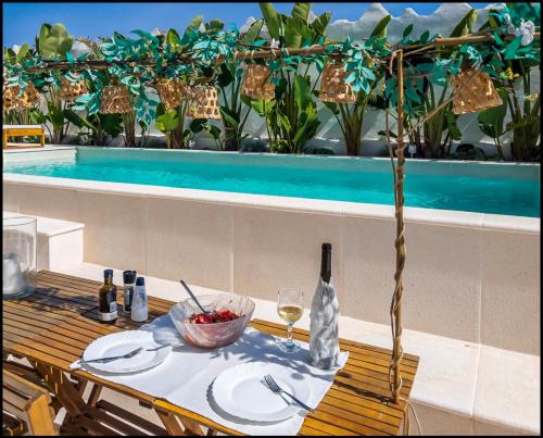 a table with a bowl of fruit and a bottle of wine at Villa Rafa in Costa Nova