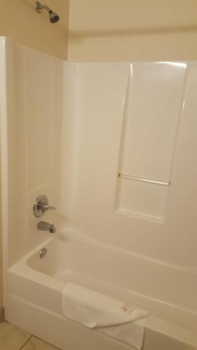 a white bathroom with a tub and a sink at The Rutledge Inn in Luverne