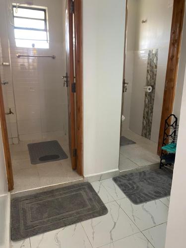 a bathroom with a shower and a glass door at Modern staycation -ruaka in Ruaka