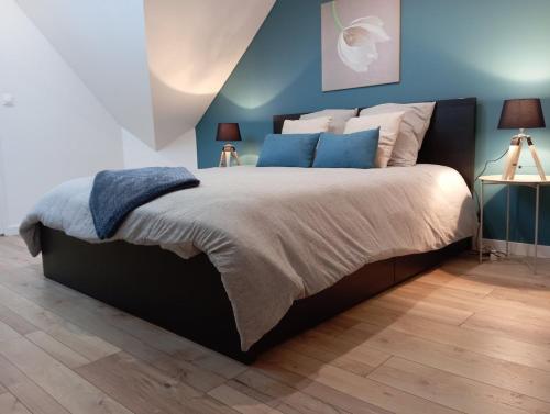 a bedroom with a large bed with blue walls at Magnifique et Grand T3 au cœur de la Normandie in Saint-Victor-lʼAbbaye