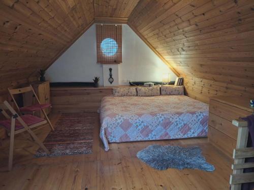 a bedroom with a bed in a wooden cabin at Chaloupka Rozmarýna in Srbce