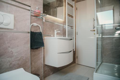 a bathroom with a sink and a shower at Deniro Apartment in Požega