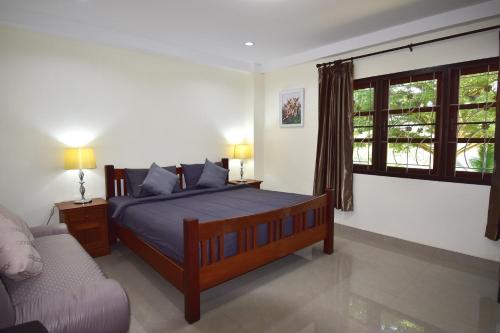 a bedroom with a bed and a couch and a window at Kate House Bangsaphan in Bang Saphan