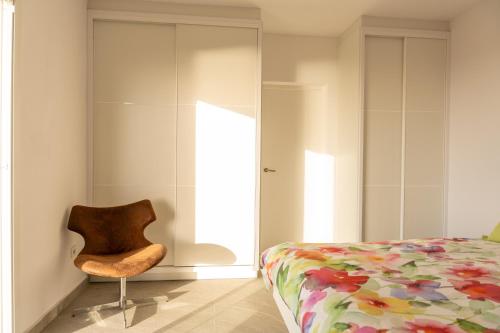 a bedroom with a bed and a chair at Finca el Vinche in Guía de Isora