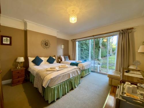 a bedroom with two beds and a large window at Pickwicks Guest House in Oxford