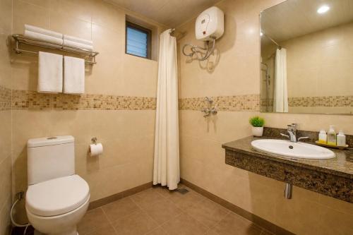 a bathroom with a toilet and a sink at Travellers Story Baga GOA in Baga