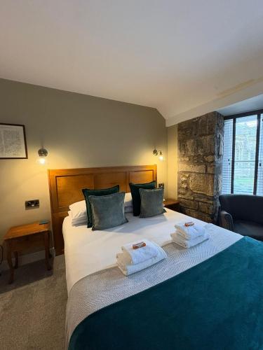 a bedroom with a large bed with towels on it at The Covenanter Hotel in Falkland