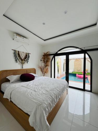 a bedroom with a large bed and a pool at Villa Suarga Loka in Tutugan