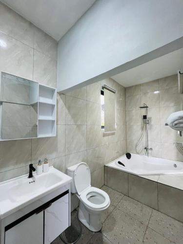 a bathroom with a toilet and a tub and a sink at Villa Suarga Loka in Tutugan
