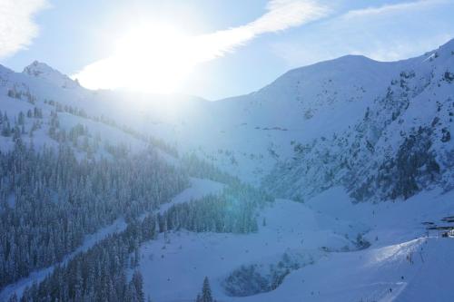 a snow covered mountain with the sun shining on it at Apart Söllbacherhof in Fügen