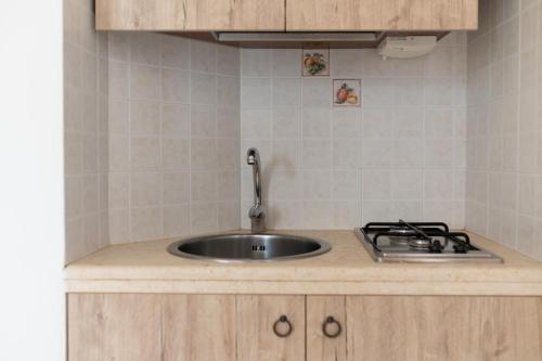 a kitchen counter with a sink and a stove at Masseria Valente in Ostuni