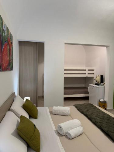 a white room with a bed with green pillows at Trinacria Rooms 1 in Carini