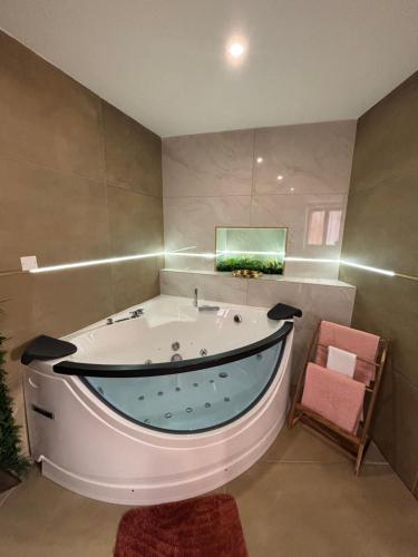 a large bath tub in a bathroom with a green aquarium at esperanza in Vizille