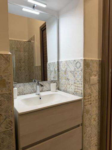 a bathroom with a white sink and a mirror at Trinacria Rooms 1 in Carini