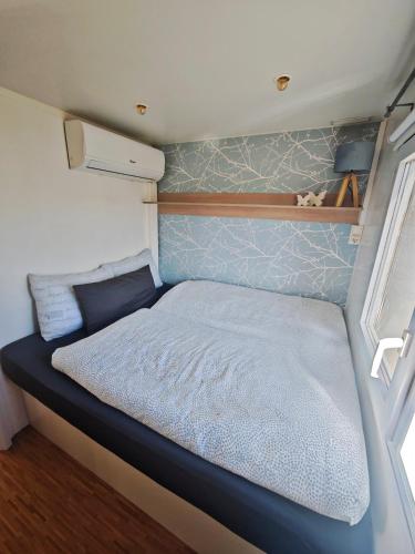 a small bedroom with a bed in a trailer at Casa Amarela-Tiny House with fantastic view-pool and close to the beaches in Silves