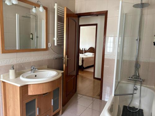 a bathroom with a sink and a shower and a tub at Casa Retiro de Xisto II in Videmonte
