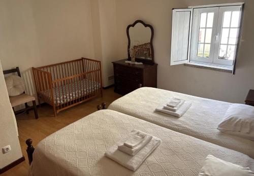 a bedroom with two beds and a crib and a mirror at Casa Retiro de Xisto II in Videmonte