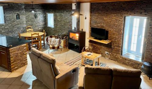 a living room with a couch and a tv and a table at Casa Retiro de Xisto II in Videmonte