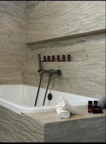 a bath tub in a bathroom with towels on a counter at KANALI HOLIDAYS APARTMENT 5 in Preveza