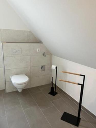 a bathroom with a white toilet in a attic at Ferienwohnung Bolle in Hooksiel