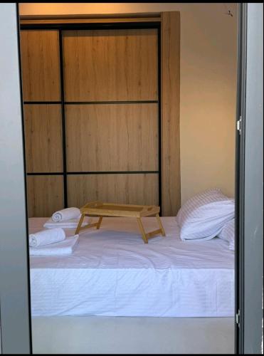 a bed with a wooden headboard and towels on it at KANALI HOLIDAYS APARTMENT 5 in Preveza