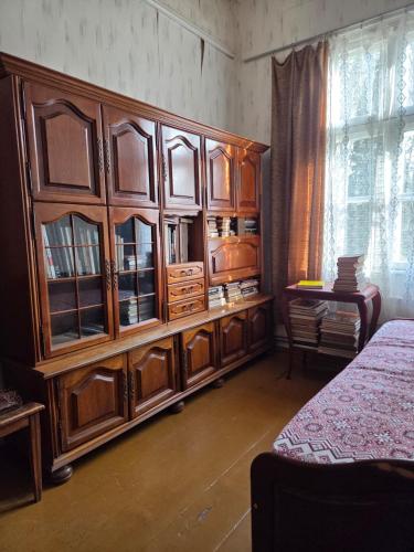 a large wooden cabinet in a room with a bed at Rozulas skola in Rozula