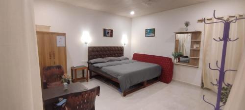 a bedroom with a bed and a table in it at Anna Cottages Agonda in Agonda
