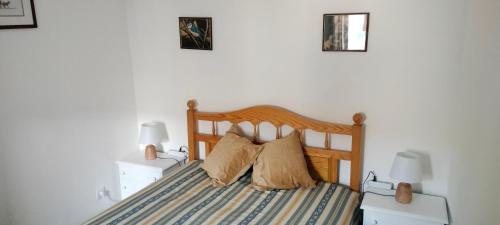 a bedroom with a wooden bed with two lamps at Casa dos Avós Palma - Alcoutim in Alcoutim