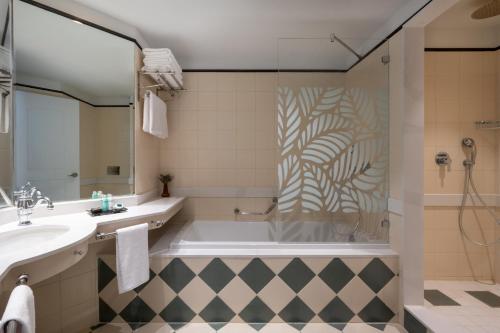 a bathroom with a tub and a sink at Herods Boutique Eilat a Premium collection by Fattal Hotels in Eilat