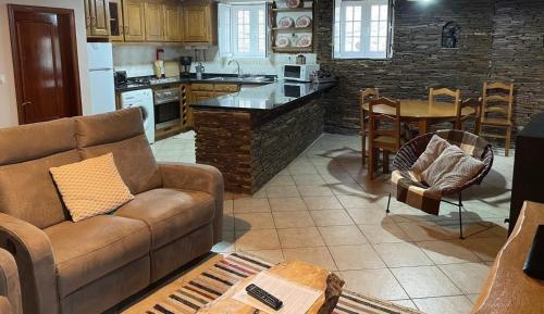 a living room with a couch and a kitchen at Casa Retiro de Xisto II in Videmonte