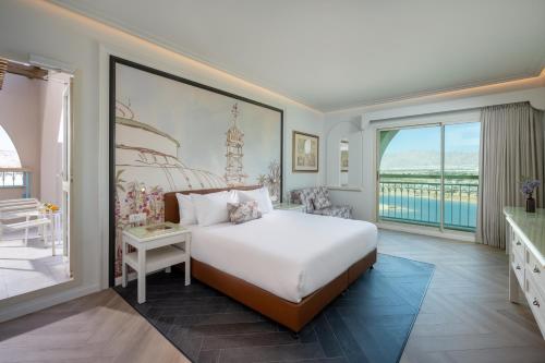 a bedroom with a bed and a large window at Herods Boutique Eilat a Premium collection by Fattal Hotels in Eilat