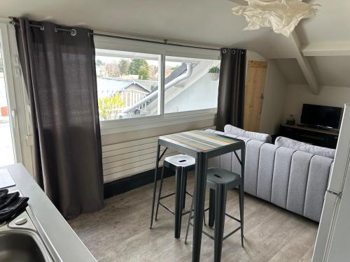 a table and two stools in a kitchen with a couch at Private studio in Loft in Tarbes in Tarbes