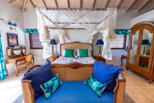 a bedroom with a bed with blue cushions at Tuckers Villa in Cobbs Cross