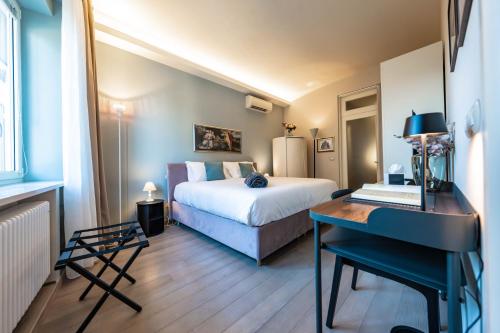 a bedroom with a bed and a desk with a piano at Cavour Suite Luxury in Bologna