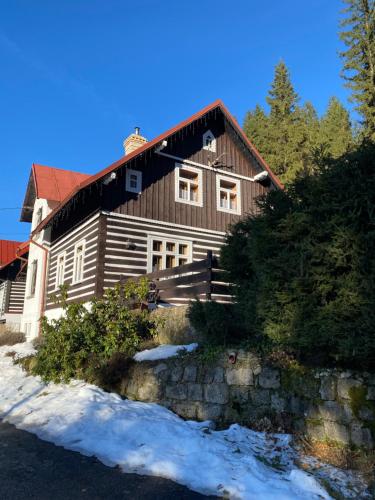 a large wooden house with snow in front of it at Chata Štefička in Josefŭv Dŭl