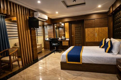a hotel room with a bed and a desk at Blue Diamond Residency in Perintalmanna