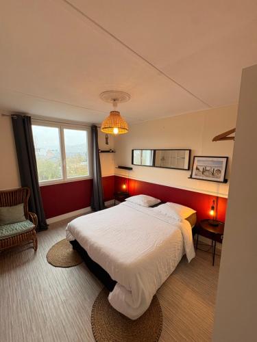 a bedroom with a large bed and red walls at Appartement Duplex The Lighthouse in Châteaulin