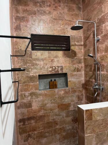 a bathroom with a brick wall with a fireplace at Villa Semoga in Tanjung
