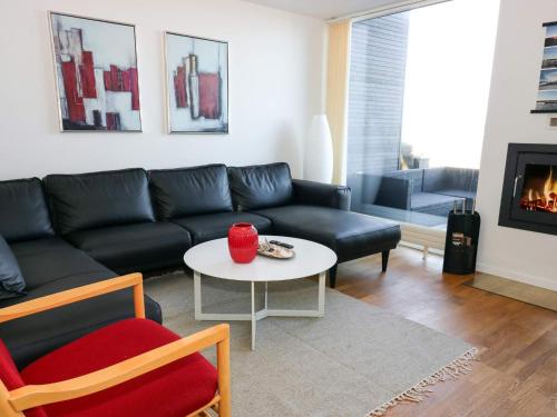 a living room with a black couch and a table at 5 star holiday home in Hadsund in Øster Hurup