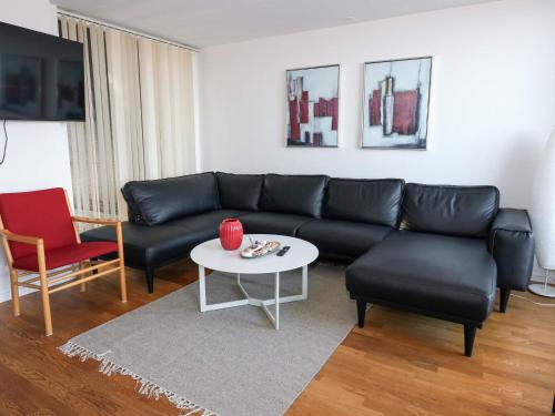 a living room with a black couch and a table at 5 star holiday home in Hadsund in Øster Hurup