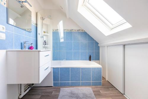 a bathroom with a white tub and blue tiles at Exceptional duplex at Disneyland Paris in Serris