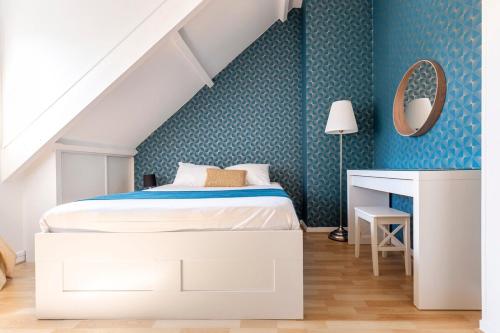 a bedroom with a white bed and a blue wall at Exceptional duplex at Disneyland Paris in Serris