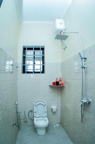 a bathroom with a shower with a toilet in it at Kibs Apartments in Dodoma
