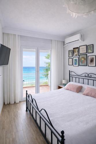 a bedroom with a bed and a view of the ocean at Ethereal Beach House in Hanioti