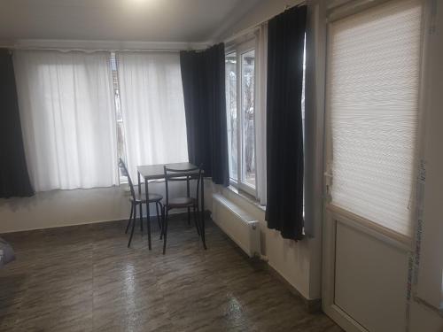 Summer Garden في تبليسي: غرفة طعام بها طاولة وكراسي ونوافذ