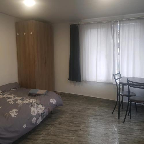 Summer Garden في تبليسي: غرفة نوم بها سرير وطاولة وكراسي