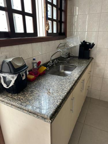eine Küche mit Spüle und Arbeitsplatte in der Unterkunft Master Home Digital QUARTOS COMPARTILHADOS in Barueri
