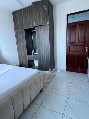 a bedroom with a bed and a wooden door at Skyview Bamburi Suites in Mombasa