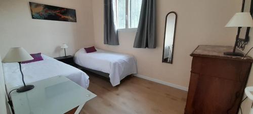 a room with two beds and a table and a mirror at Haut de villa calme, 2 chambres et vue dégagée - proche calanques in Roquefort-la-Bédoule